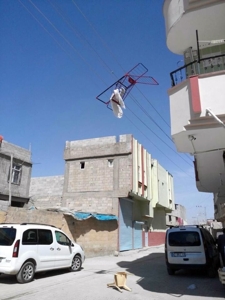 Rüzgarda uçan çamaşır kurutmalığı elektrik teline takıldı